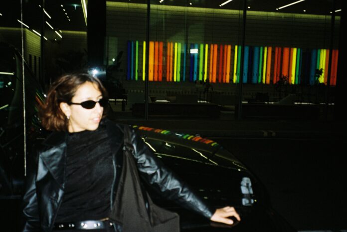 Fun photo of Malika leaning against a car