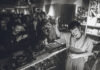 Tomoki Tamura DJing in a crowded record shop, black and white photo