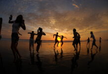Dancers silhouetted against a sunset at a 4Beats event